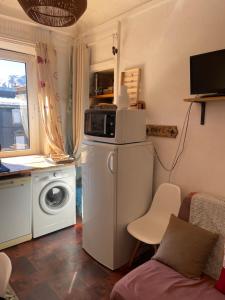 a kitchen with a microwave and a washing machine at T2 Hyper centre le mont dore face thermes et cure in Le Mont-Dore