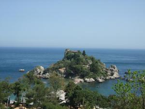 
a large body of water with a mountain range at Hotel Isola Bella in Taormina
