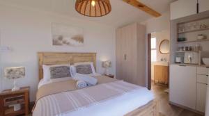 a bedroom with a large bed and a kitchen at Khayalena Beach House - Tides Reach in Umdloti