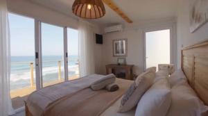 a bedroom with a bed with a view of the ocean at Khayalena Beach House - Tides Reach in Umdloti +16 photos
