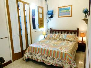 1 dormitorio con 1 cama con edredón en Casa do Jardim, en Río de Janeiro