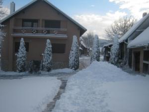 una casa con un montón de nieve delante de ella en House Pribić, en Vrelo Koreničko