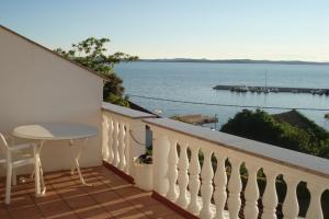 a balcony with a table and a view of the water at Pansion Marco Polo in Petrcane