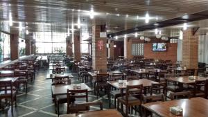 a dining room filled with tables and chairs at Cumbipar King Hotel in Guarulhos