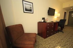 ein Hotelzimmer mit einem Stuhl, einem Schreibtisch und einem TV in der Unterkunft Holiday Inn Leon, an IHG Hotel in León