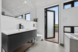 a bathroom with a sink and a toilet at Luxurious Holiday Home with Sauna & Outdoor Hot Tub in Hejls +55 photos