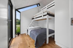 a bedroom with a bunk bed and a window at Luxurious Holiday Home with Sauna & Outdoor Hot Tub in Hejls