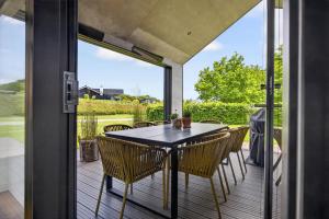 a patio with a table and chairs on a deck at Luxurious Holiday Home with Sauna & Outdoor Hot Tub in Hejls