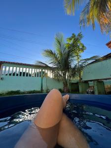 a woman laying in a pool with her legs in the water at Casa Maré in Soure