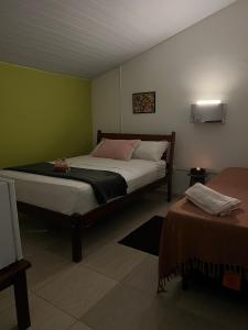 a bedroom with a bed in a room with green walls at Casa Maré in Soure