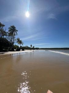 a beach with palm trees and the moon in the sky at Casa Maré in Soure