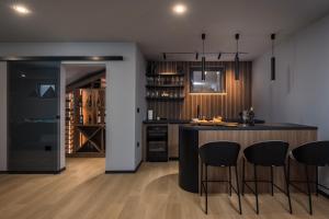a kitchen with a bar with chairs and a wine cellar at Villa Dujma Pool & Spa in Kostrena