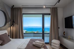 a bedroom with a bed and a large window at Villa Dujma Pool & Spa in Kostrena