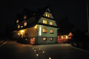 a large house with lit up windows at night at Willa Helena in Poronin
