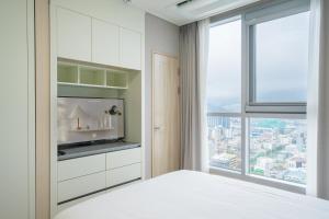 a bedroom with a large window and a white bed at Elmomento Sasang in Busan