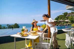 two women standing around a table with food on it at Ayara Kamala Resort & Spa in Kamala Beach +71 photos