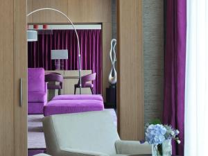 a living room with purple beds and a table at Sofitel Dubai Downtown in Dubai