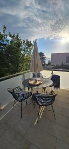 a patio with a table and chairs and an umbrella at Apartment with private pool in Njivice
