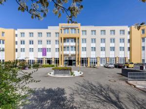a large white building with a courtyard in front of it at Mercure Hotel Stuttgart Gerlingen in Gerlingen