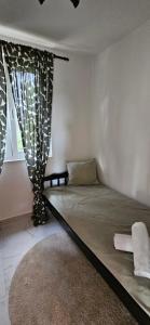 a bed in a room with a window and a rug at Apartment with private pool in Njivice