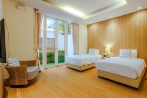 a hotel room with two beds and a window at Andaman Pool Villas, Maikhao Beach Phuket in Mai Khao Beach +57 photos