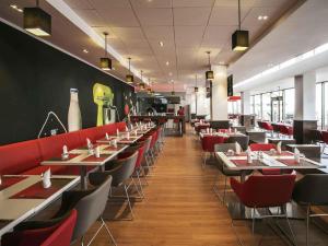 a dining room with tables and red chairs at Ibis Lagos Ikeja in Ikeja