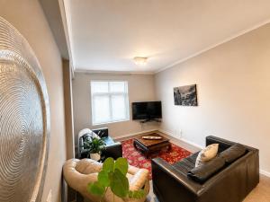 a living room with a couch and a tv at Muizenberg Surfers corner and Beach Paradise in Cape Town