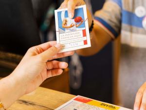 a person holding up a card in front of a table at Ibis Budget Sevilla Aeropuerto in Seville