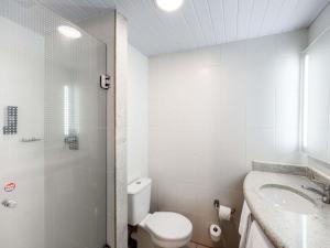 a white bathroom with a toilet and a sink at ibis Ourinhos in Ourinhos +62 photos