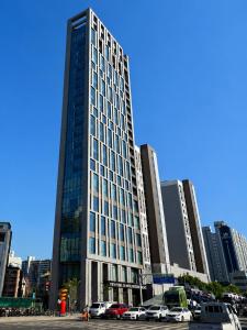 a tall building with cars parked in a parking lot at Western Palace Hotel in Incheon