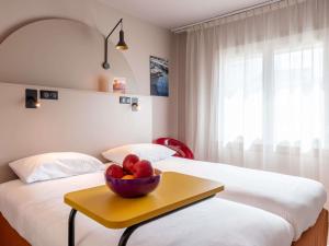 a room with two beds with a bowl of fruit on a table at ibis Styles Marseille Centre Prado Place Castellane in Marseille