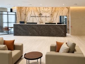 a hotel lobby with two couches and a reception desk at Western Palace Hotel in Incheon