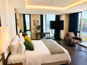 a hotel room with a bed and a flat screen tv at Western Palace Hotel in Incheon