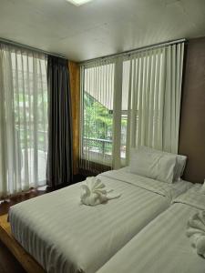 a bedroom with two beds with white sheets and windows at Rim Tarn Phu View Chiang Mai in Ban Khanin Tai +105 photos