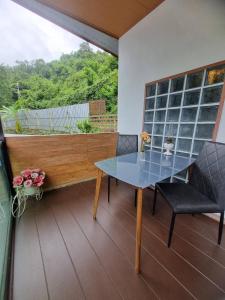 a table and chairs in a room with a window at Rim Tarn Phu View Chiang Mai in Ban Khanin Tai