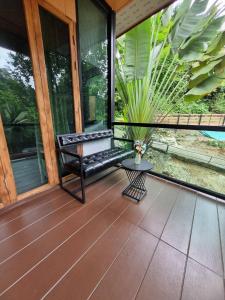 a screened porch with a bench and a table at Rim Tarn Phu View Chiang Mai in Ban Khanin Tai