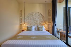a bedroom with a large bed and a large window at Rest U Guest House in Nusa Penida