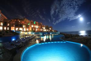 a hotel with a swimming pool at night at Club Regina Los Cabos in San José del Cabo