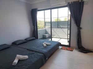 a bedroom with a bed and a large window at Maison Art in Quy Nhon