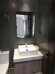 a bathroom with a white sink and a mirror at Maison Art in Quy Nhon