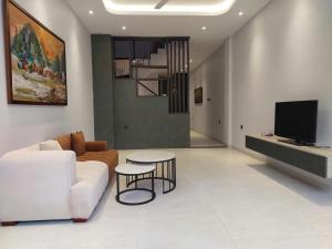 a living room with a couch and a table and a tv at Maison Art in Quy Nhon