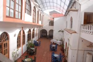 an empty courtyard with tables and chairs in a building at Hostal Tukos La Casa Real in Potosí