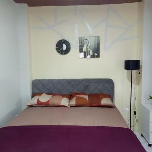 a bedroom with a bed and a clock on the wall at Engil's Studio in San Jose Dinagat Islands Philippines in Bulawan