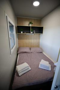 a bed in a small room with two towels on it at Ivan in Kalnik