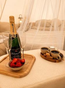 a bottle of champagne and a plate of strawberries on a table at Glamping Tisá in Tisá