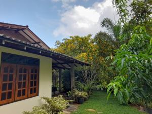 a house with a door and a garden at KADUPUL Hiriketiya in Hiriketiya