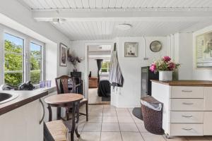 a kitchen with a sink and a table at Idyllic Old Cottage With Low Ceilings in Bredebro
