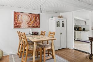 a dining room with a wooden table and chairs at Idyllic Old Cottage With Low Ceilings in Bredebro +30 photos