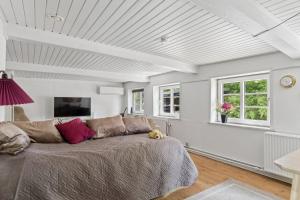 a living room with a bed and a tv at Idyllic Old Cottage With Low Ceilings in Bredebro