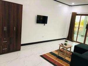 a living room with a couch and a tv on a wall at Safe Haven Residence in Talibon +14 photos